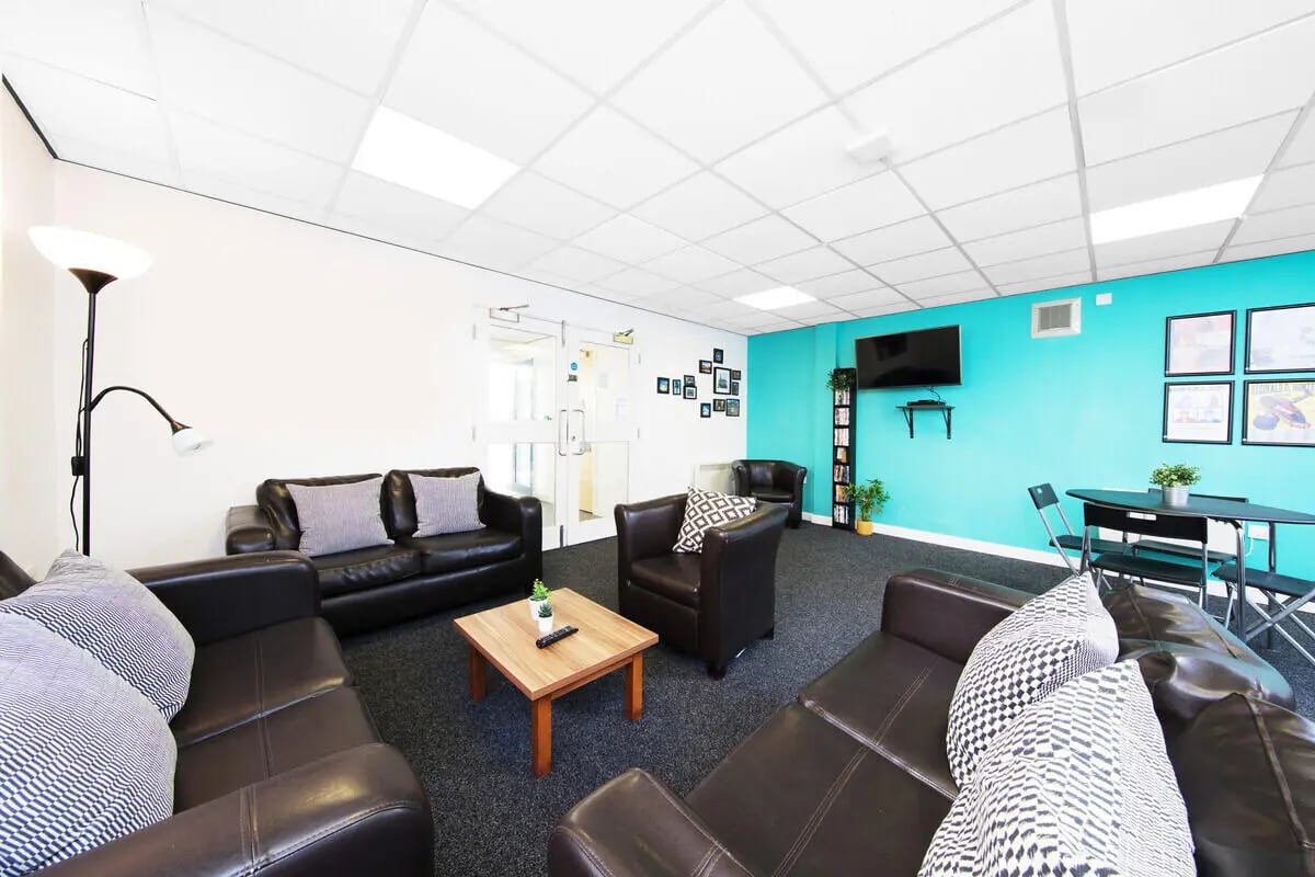 Brown sofas armchair coffee table television living room at Prospect Point in Liverpool Student Accommodation
