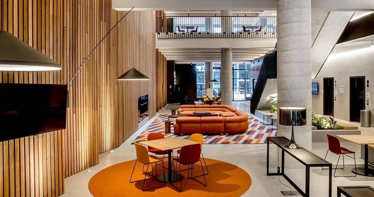 Modern lounge with orange sofa and chairs living room at Iglu South Yarra in Melbourne Student Accommodation