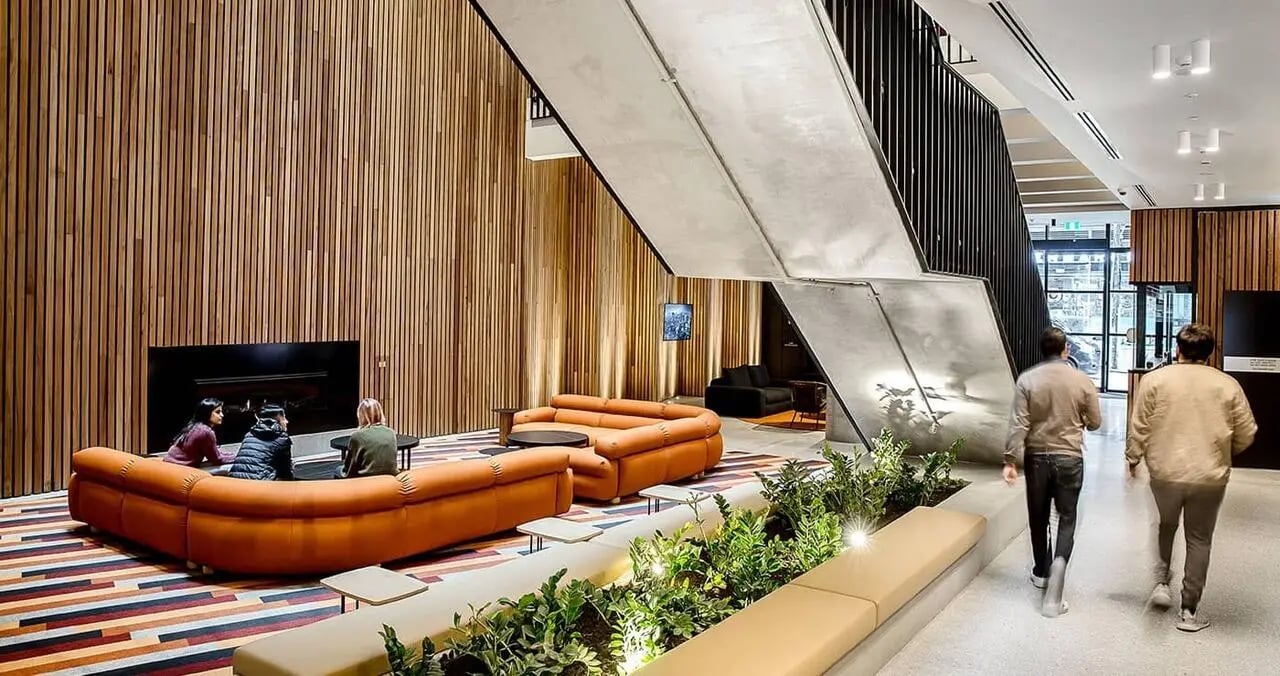 Students seated on sofas near fireplace living room at Iglu South Yarra in Melbourne Student Accommodation