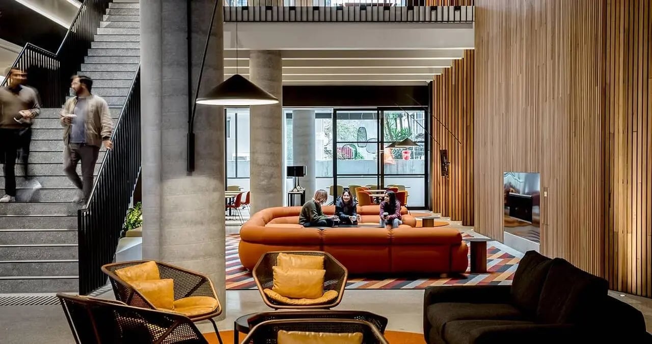 Modern communal area with orange sofa and chairs living room at Iglu South Yarra in Melbourne Student Accommodation