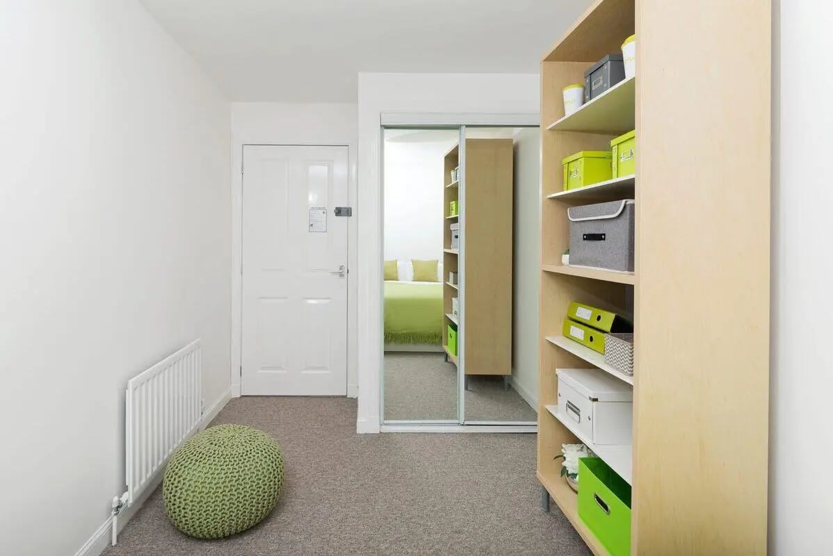 Green ottoman radiator white door bedroom view living room at Trinity Court in Aberdeen Student Accommodation