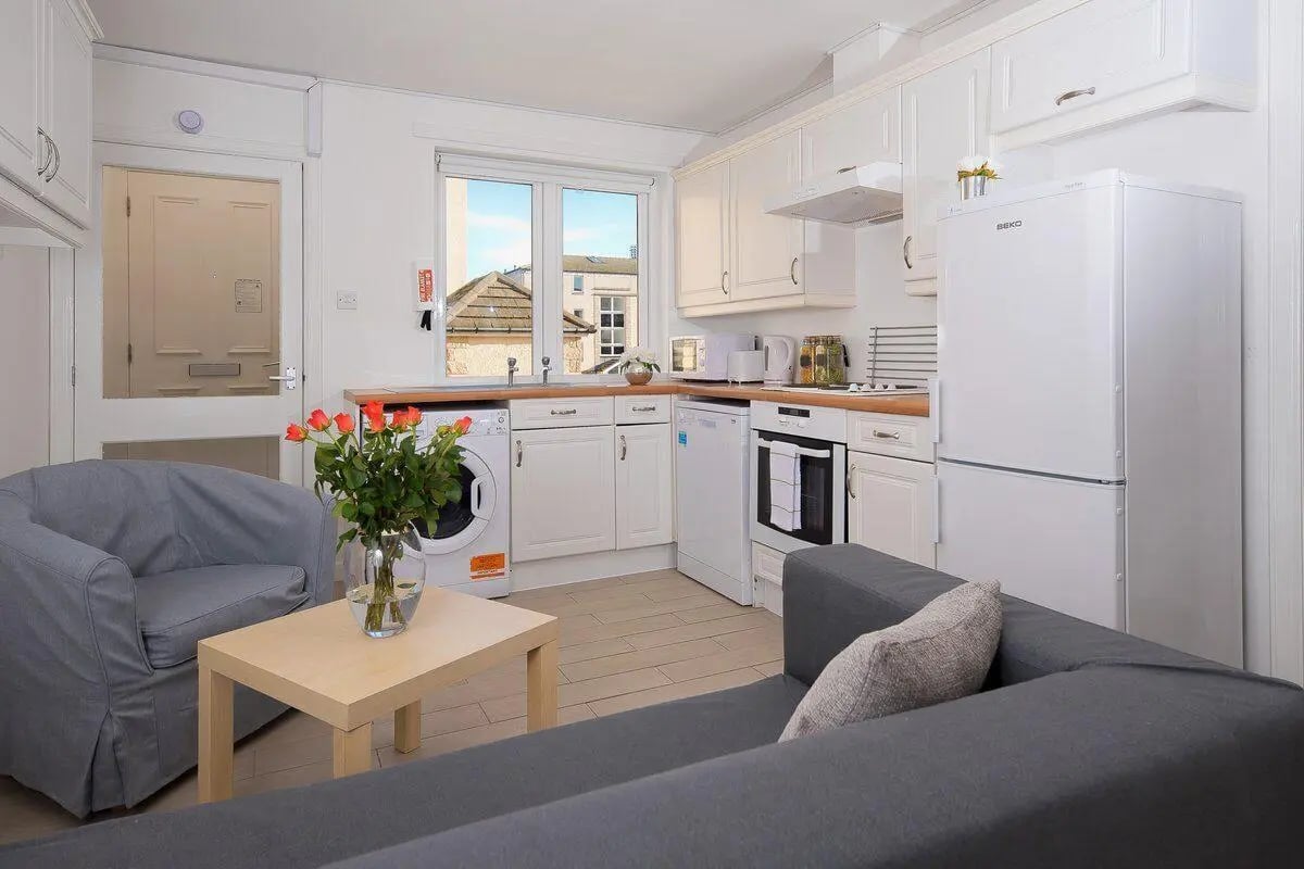 Sofa chairs table washing machine fridge kitchen at Trinity Court in Aberdeen Student Accommodation