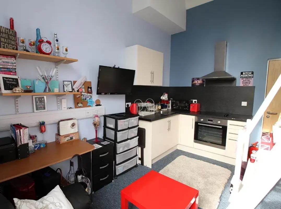 Desk shelves TV kitchen cabinets and oven kitchen at Radmoor House in Loughborough Student Accommodation