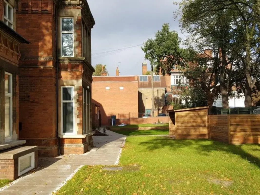 Brick building pathway green grass wooden shed exterior at Regent Road in Leicester Student Accommodation