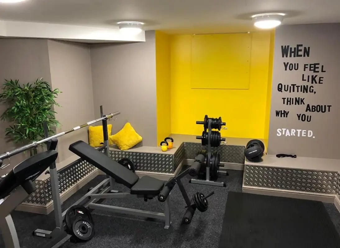 Bench barbell weights plant and motivational text gym at Regent Road in Leicester Student Accommodation