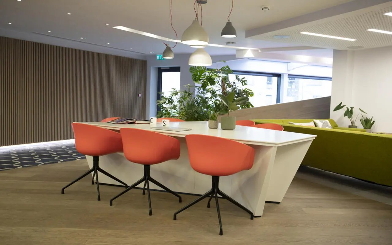 Orange chairs at white table plants living area at Student Castle Cambridge in Cambridge Student Accommodation