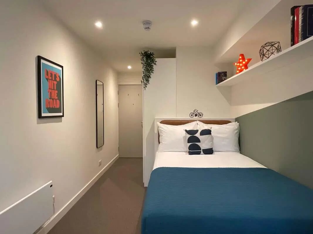 Bed with pillows and blue blanket bedroom at Snow Island in Huddersfield Student Accommodation