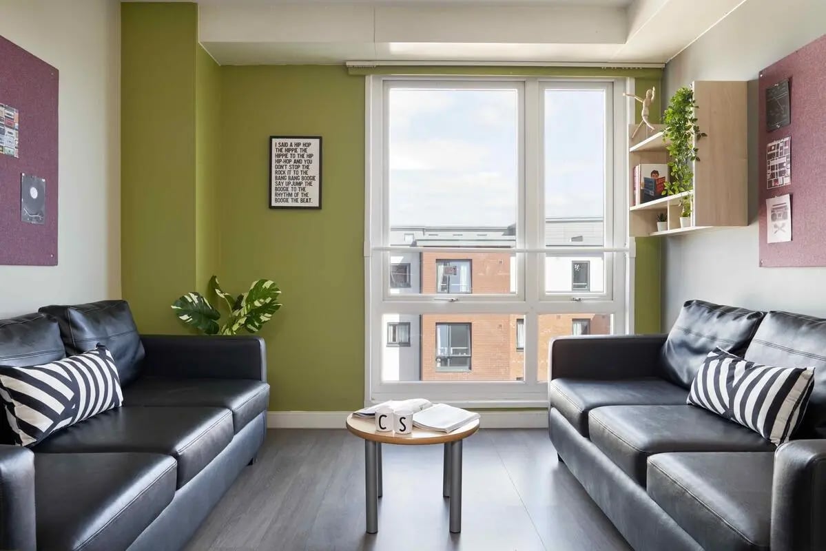 Two black sofas small table books living room at Central Quay in Sheffield Student Accommodation