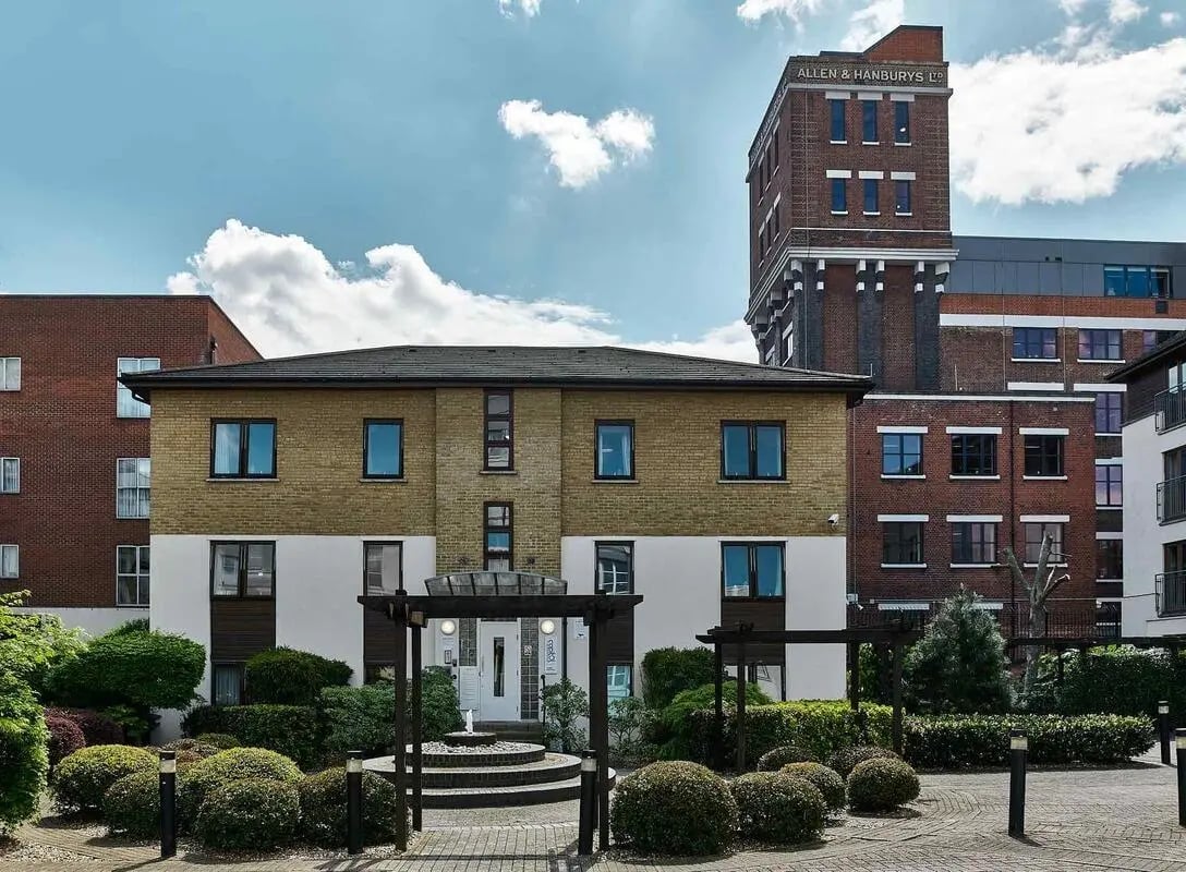 Modern apartment building entrance with fountain and landscaping exterior at Sunlight Apartments in London Student Accommodation