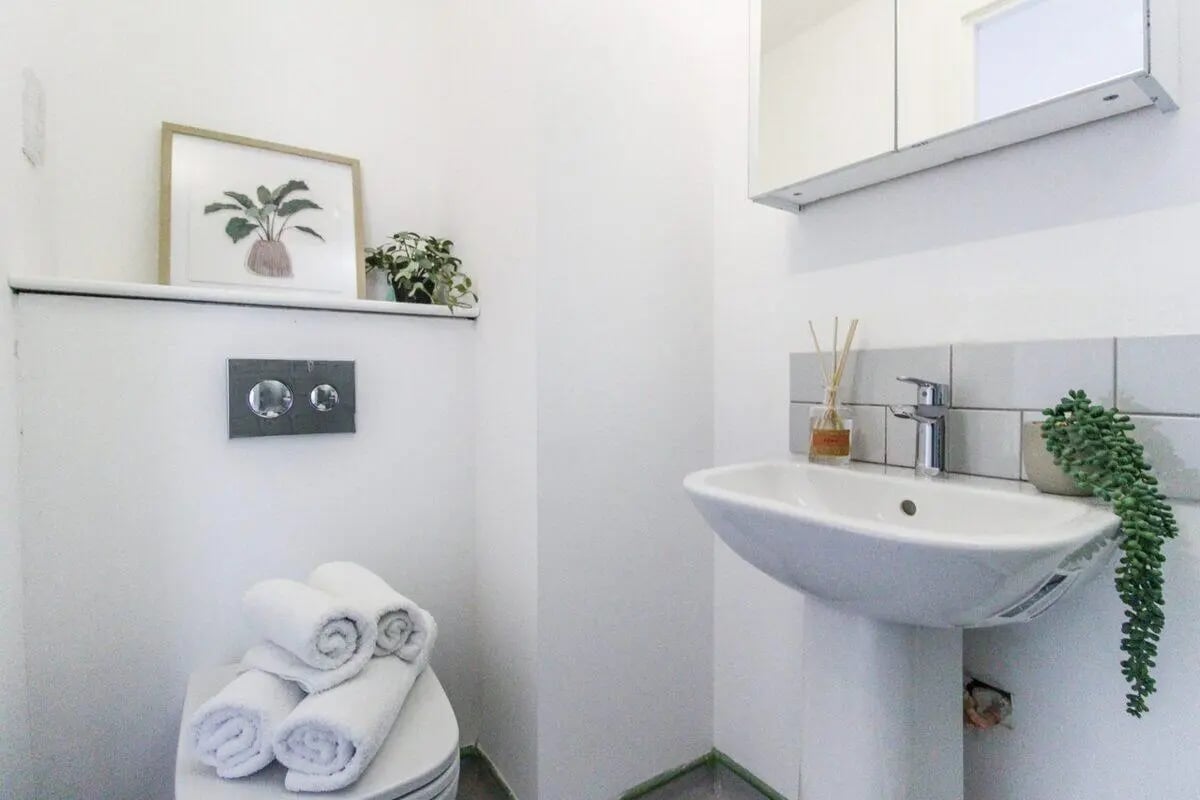 Toilet with towels framed art sink with diffuser Bathroom at The Nest Leicester in Leicester Student Accommodation