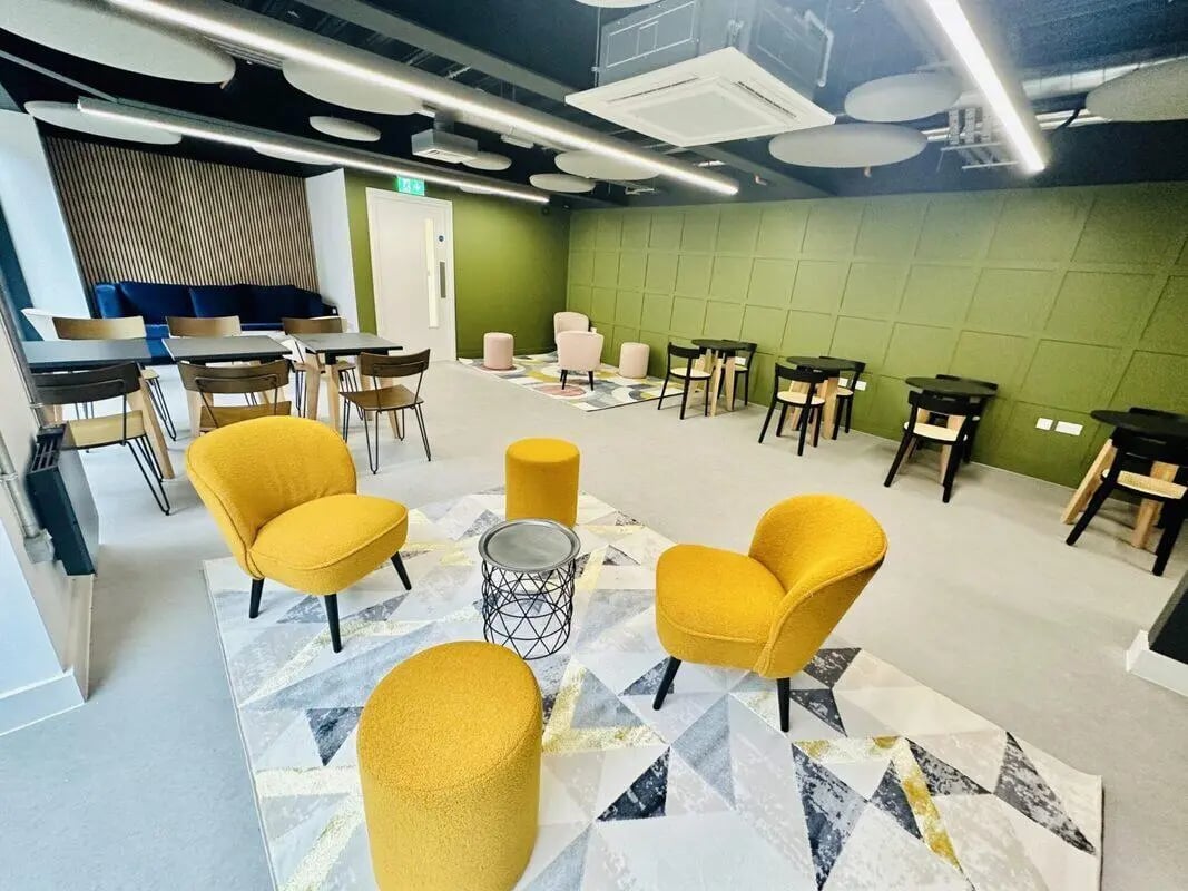 Yellow chairs round poufs tables and seating area. at The Nest Leicester in Leicester Student Accommodation