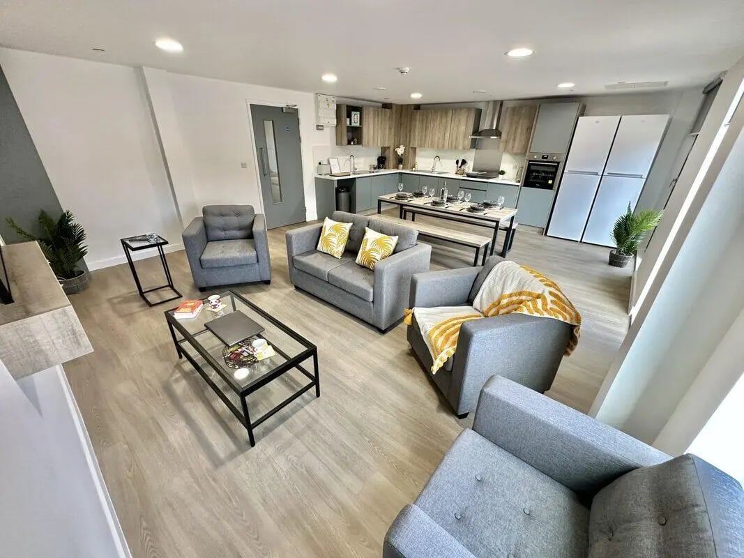 Modern living room with sofas dining table kitchen exterior at Albany Student Village in Coventry Student Accommodation