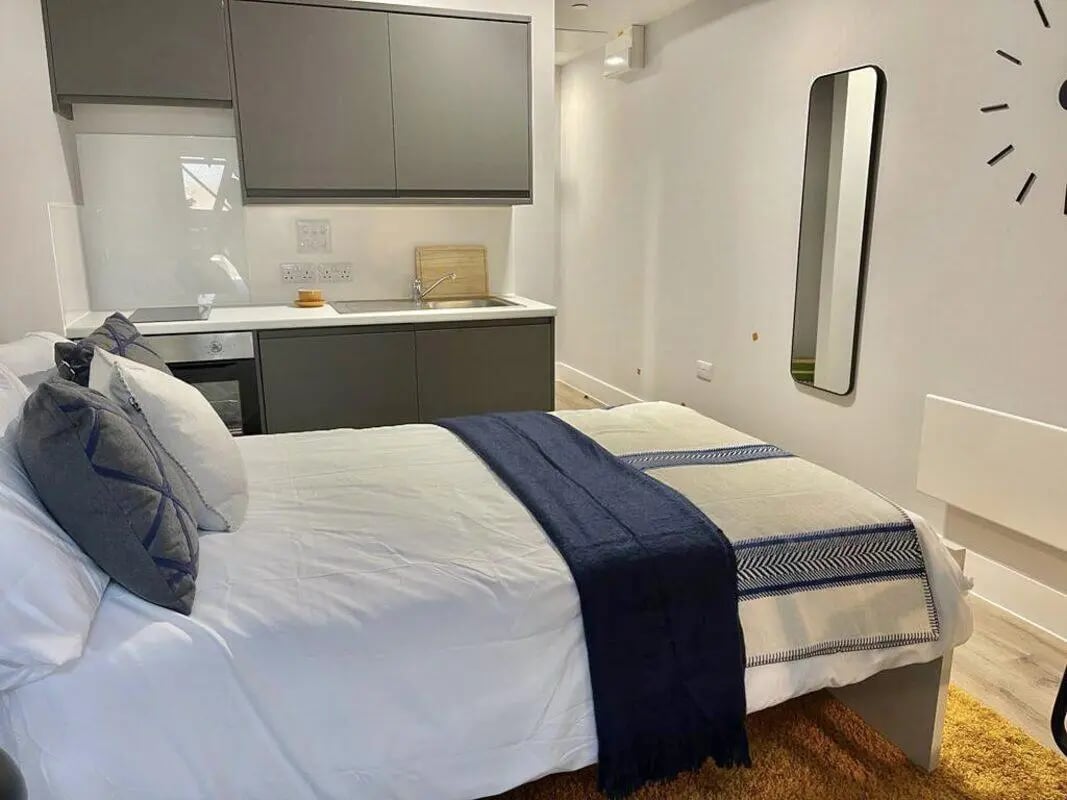 Bed with kitchen area and mirror Bedroom at Hydrogen Falmouth in Falmouth Student Accommodation