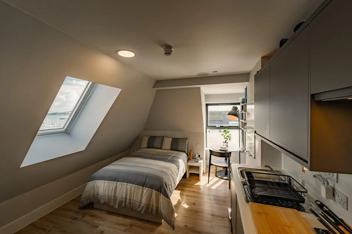 Bed, table, and kitchen with skylight bedroom at Hydrogen Falmouth in Falmouth Student Accommodation
