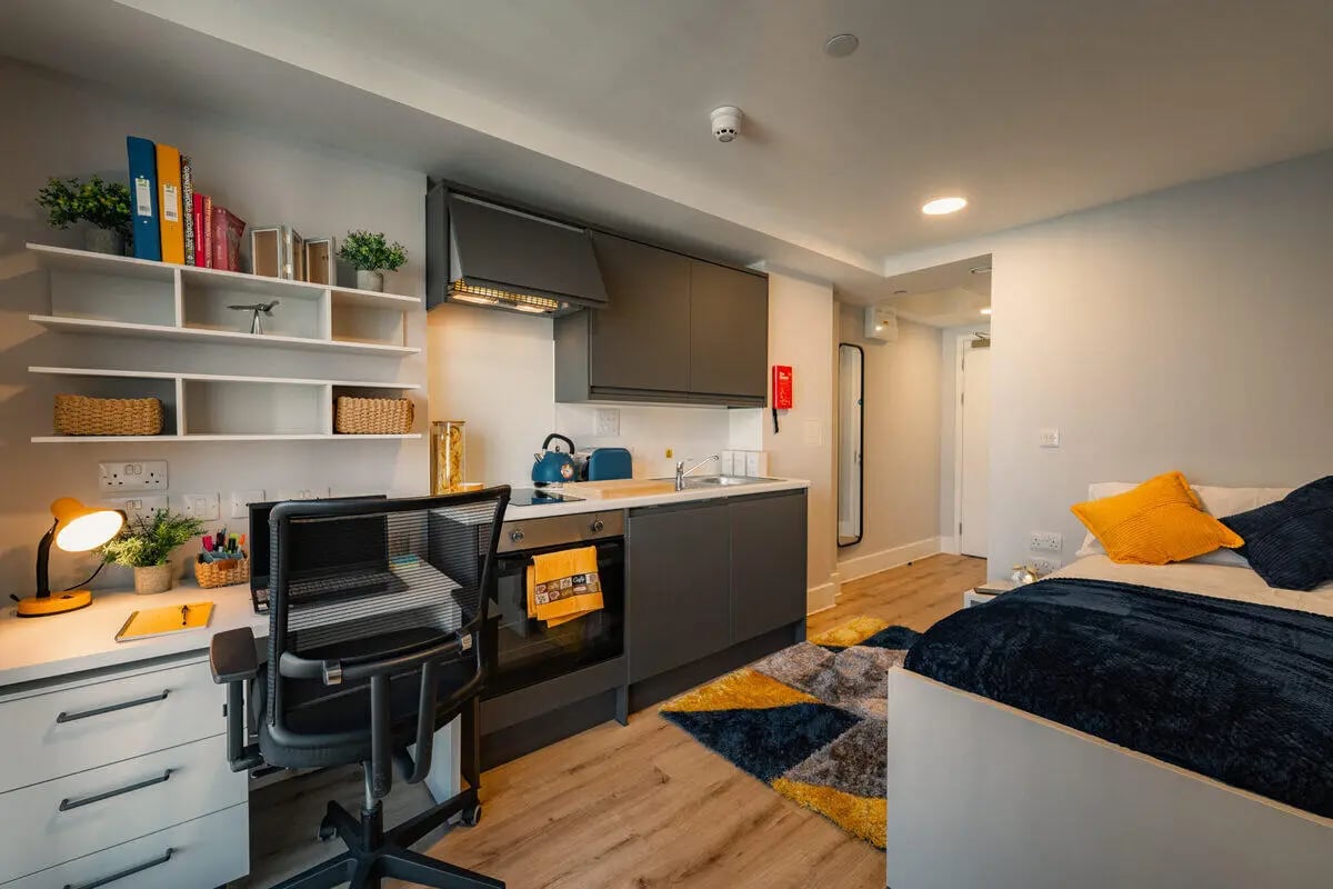 Desk bed kitchen area and shelving unit studio apartment at Hydrogen Falmouth in Falmouth Student Accommodation