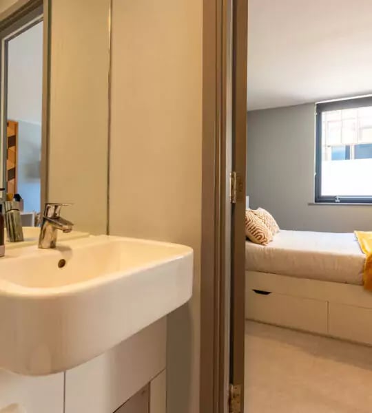 Sink and faucet with open bedroom beyond bedroom at The Walls in Southampton Student Accommodation