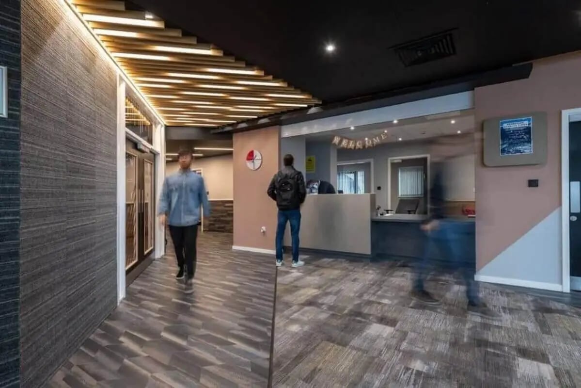 Welcome area with reception desk and people exterior at West Village in Glasgow Student Accommodation
