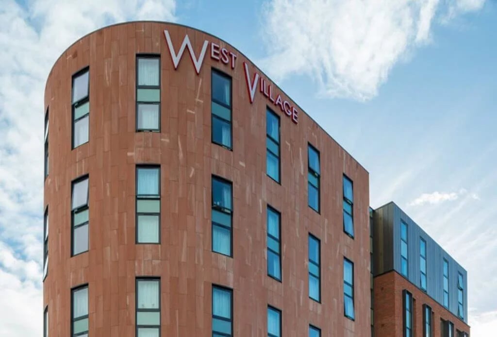 Curved building with West Village sign exterior at West Village in Glasgow Student Accommodation