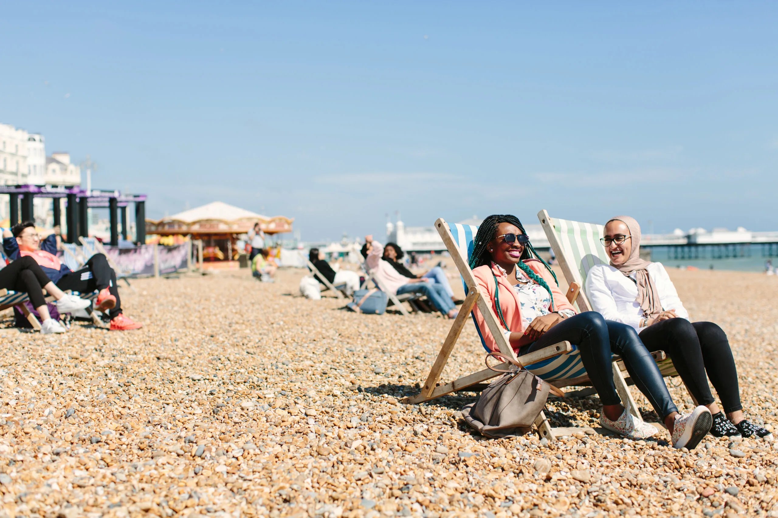 Two women relax on beach chairs outdoor area at Kaplan Living Brighton in Brighton Student Accommodation