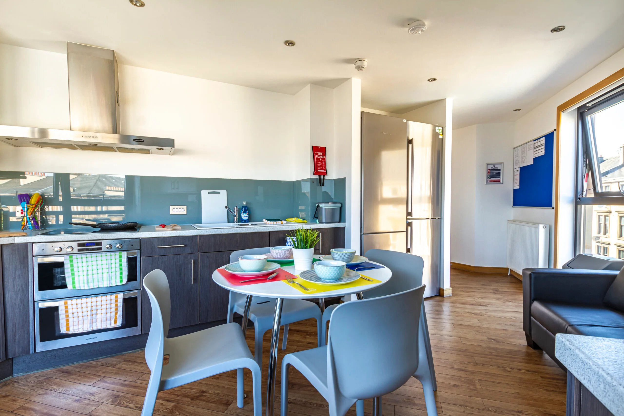 Kitchen with dining table refrigerator and sofa kitchen at Kaplan Living Glasgow - Argyle Street in Glasgow Student Accommodation