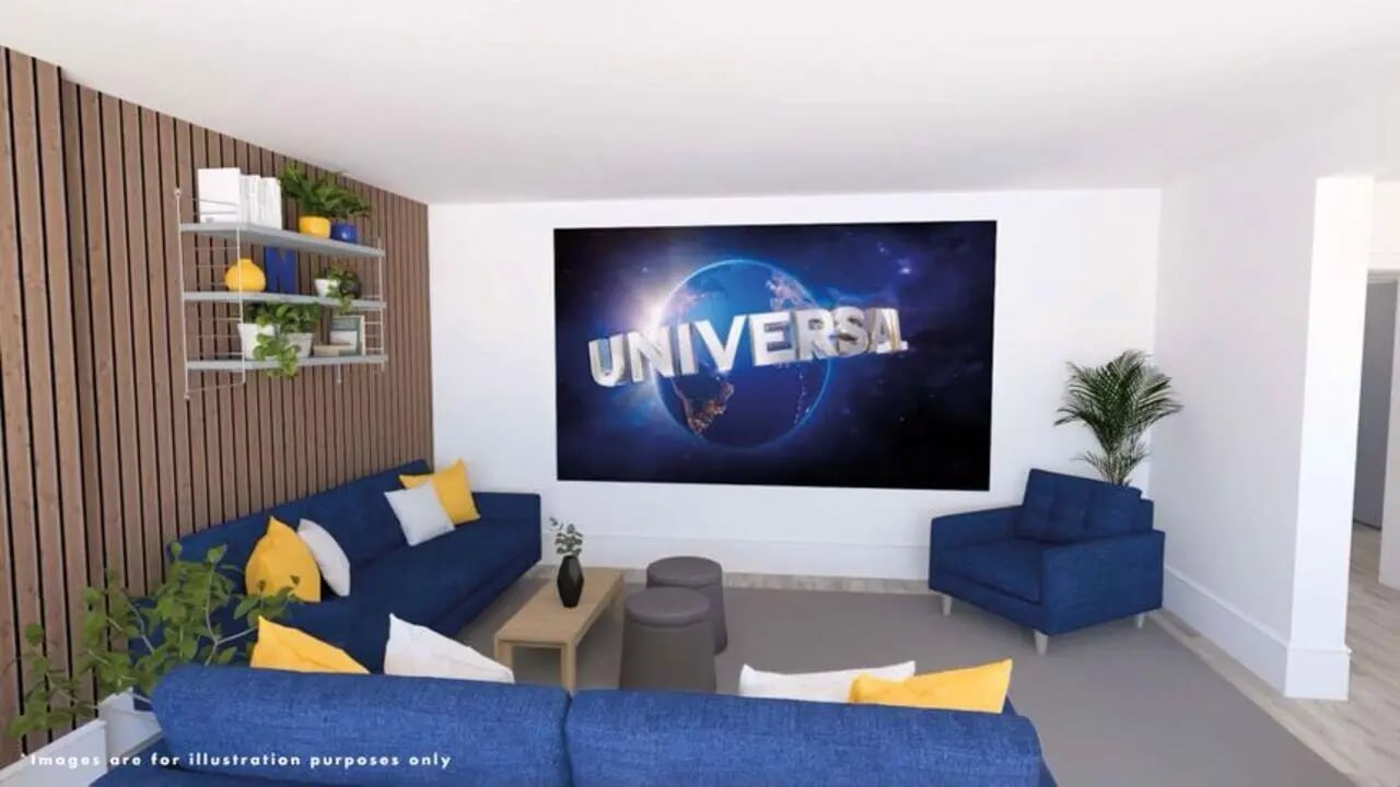 Blue sofas projector screen and plants living room at Singer Hall in Coventry Student Accommodation