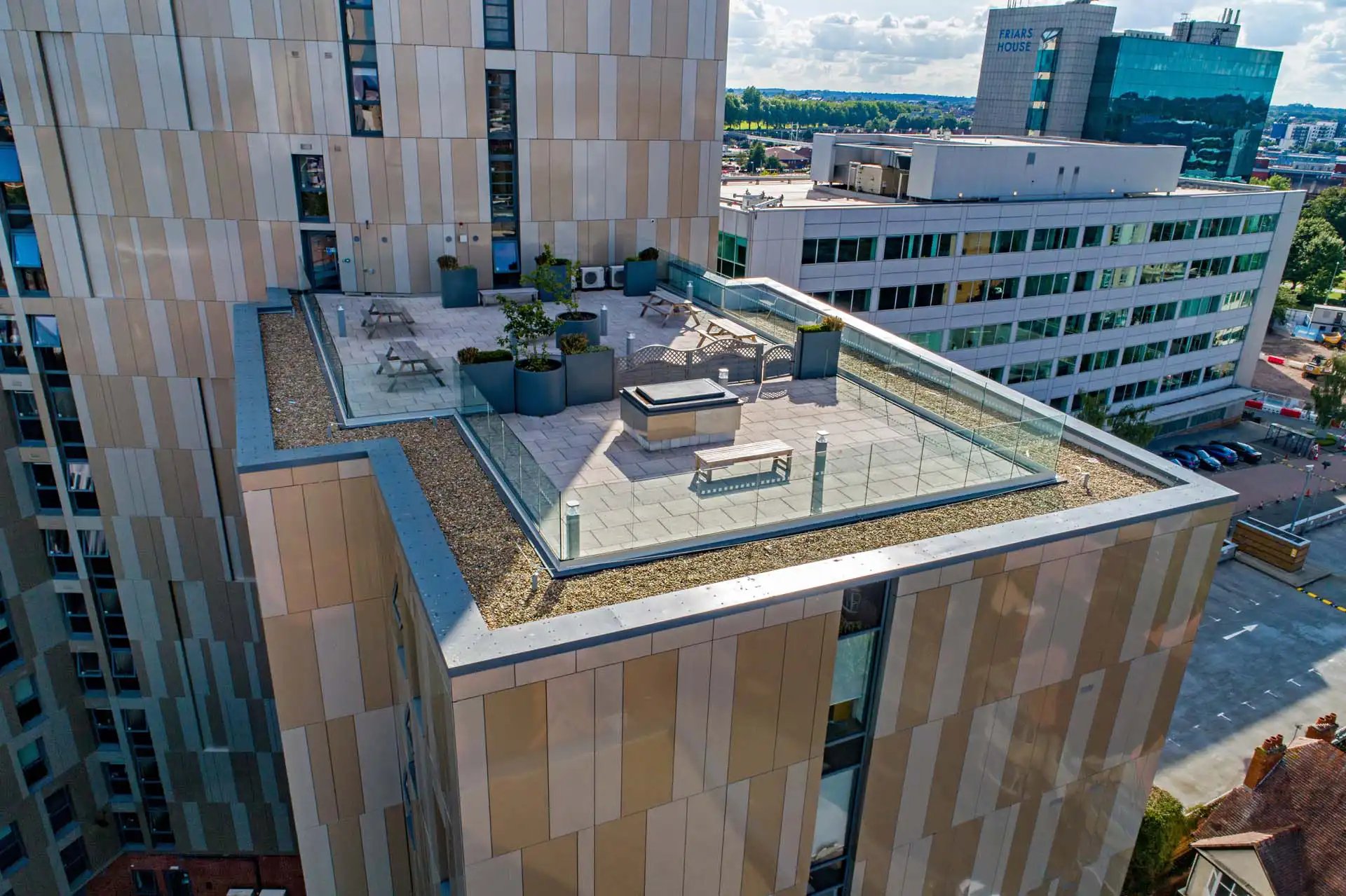 Rooftop seating with tables and planters exterior at Trinity View Coventry in Coventry Student Accommodation