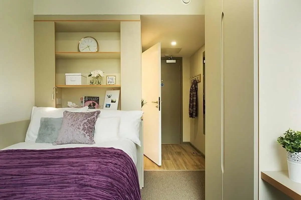 Bed with purple blanket and shelves bedroom at Liv Dublin in Dublin Student Accommodation