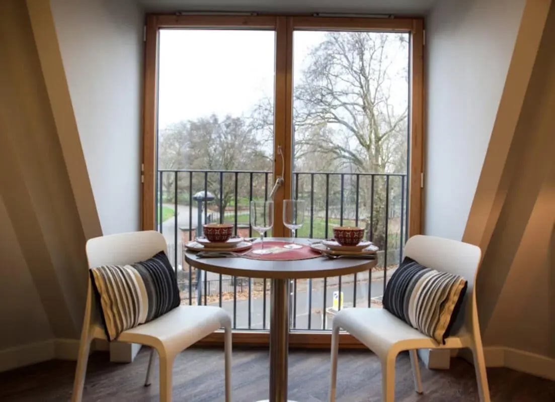 Two chairs table setting balcony view living room at Halsmere Studios in London Student Accommodation