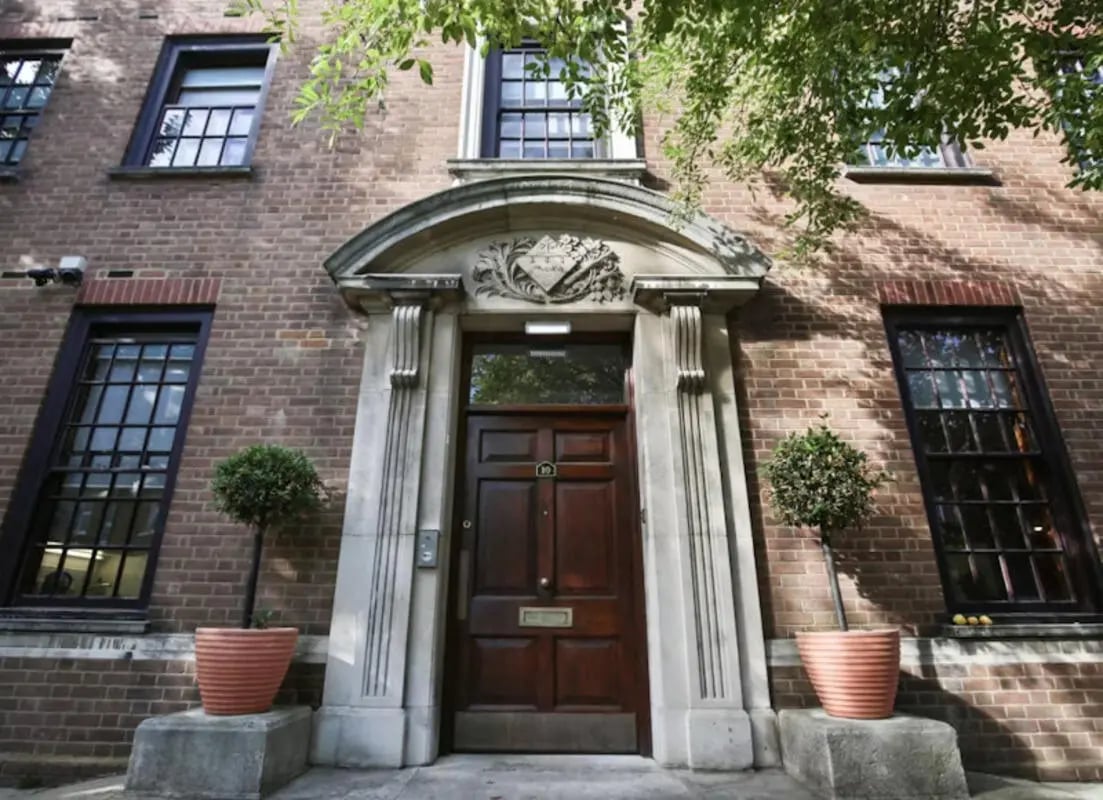 Brick building entrance with potted trees exterior at Halsmere Studios in London Student Accommodation