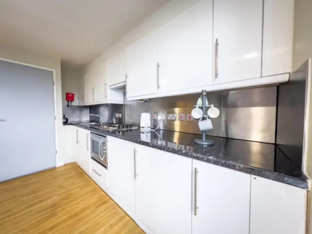 White cabinets microwave sink and mugs kitchen at Lady Nicolson Court in Edinburgh Student Accommodation