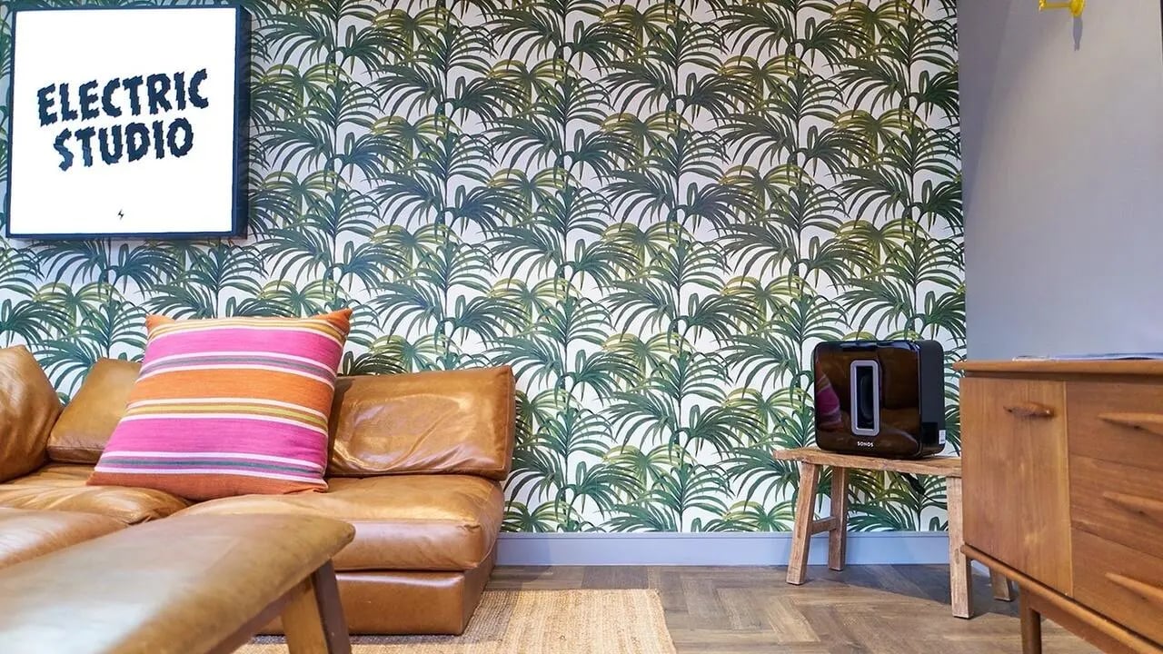 Brown sofa Sonos speaker tropical wallpaper living room at Canvas The Parade in Cardiff Student Accommodation