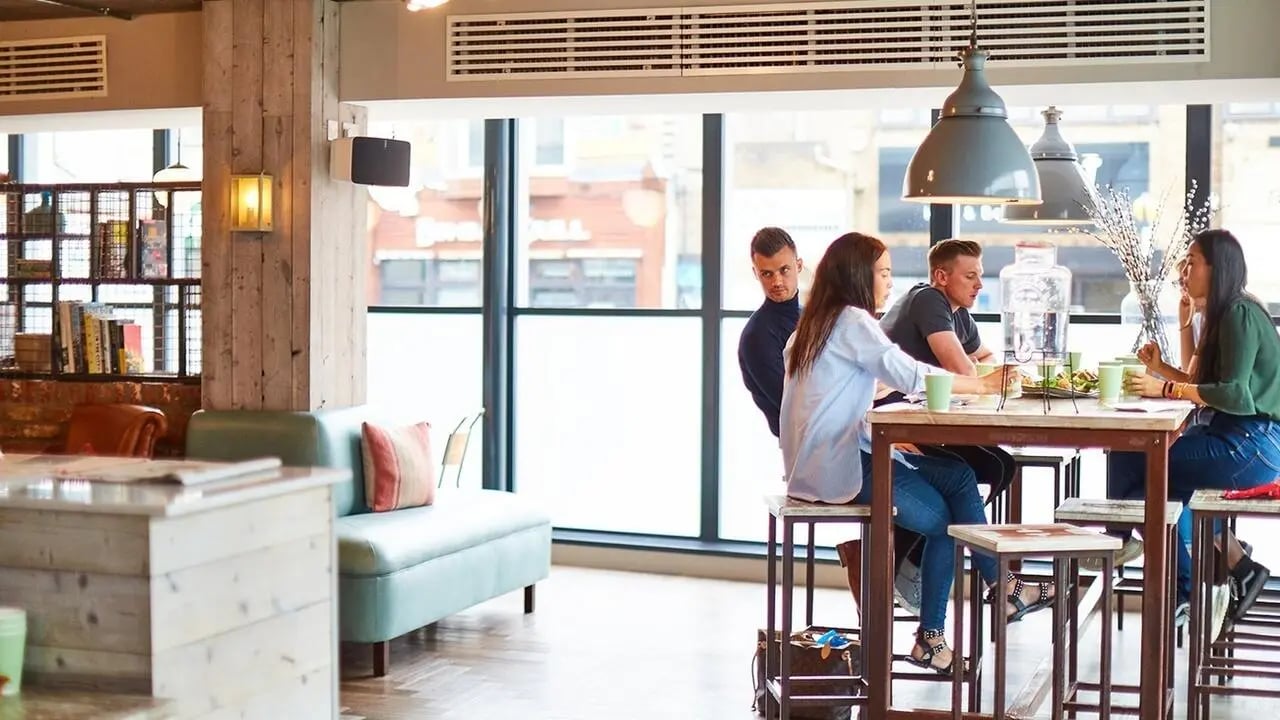 Students eating at high tables with modern lamps living room at Canvas The Parade in Cardiff Student Accommodation