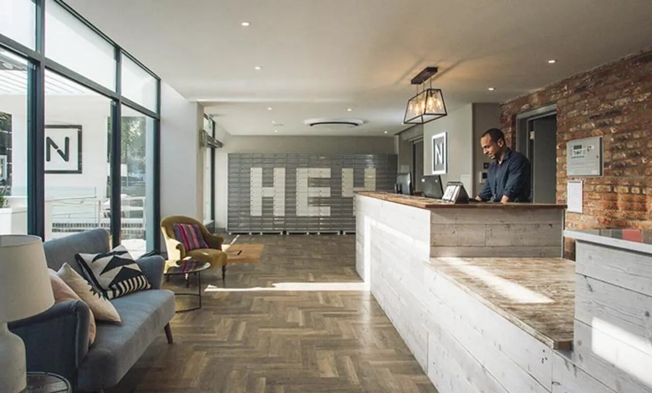 Reception desk with seating area and lockers. at Canvas The Parade in Cardiff Student Accommodation