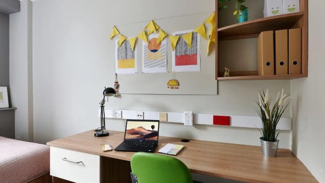 Desk with laptop plant and bed study area at Northernhay House in Exeter Student Accommodation