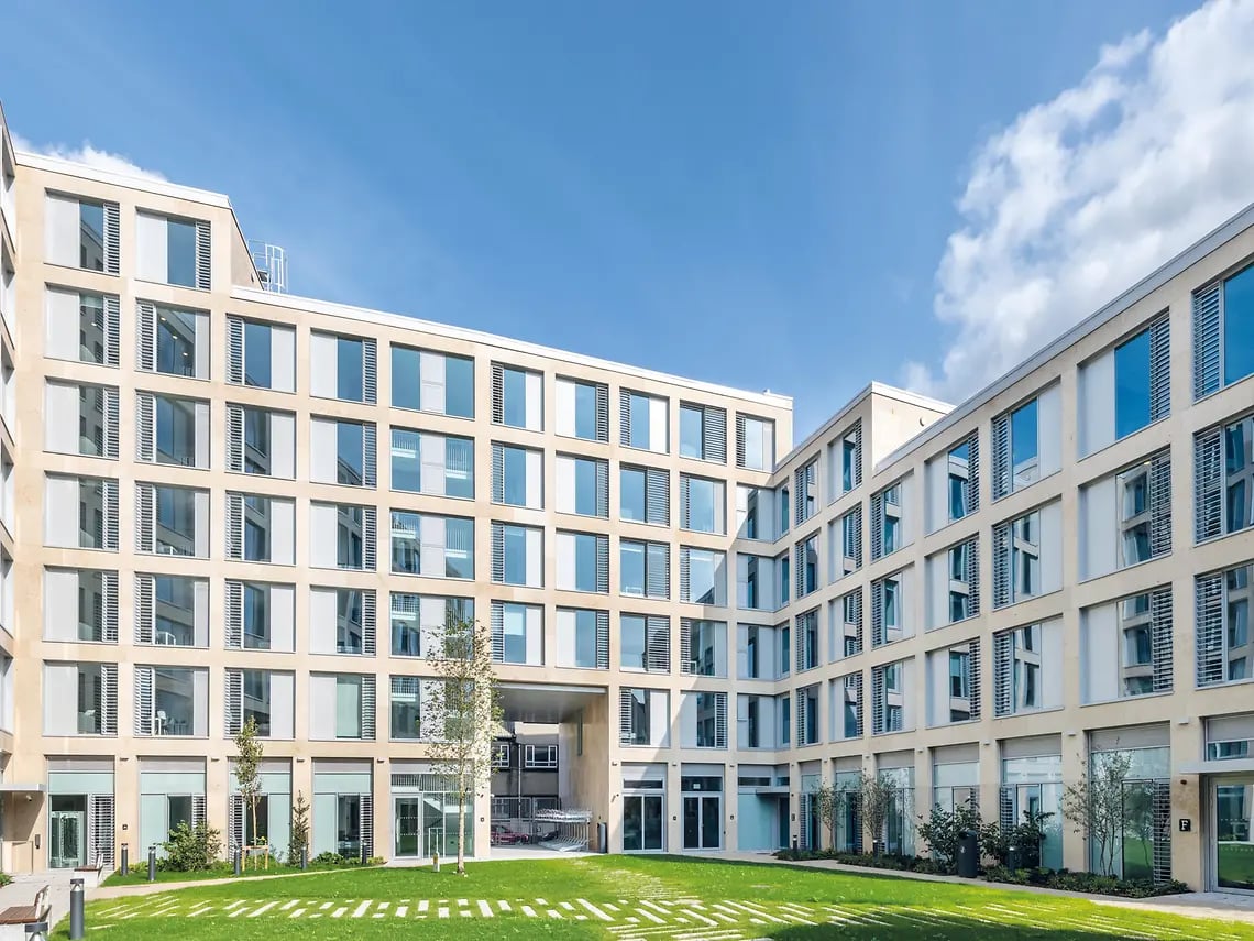 Courtyard with modern building and green lawn exterior at The Tannery in Dublin Student Accommodation