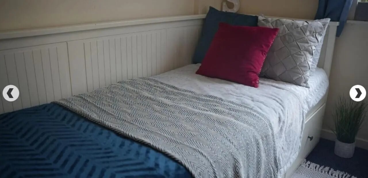 Bed with blue and grey blankets and pillows bedroom at Dinwiddy House in London Student Accommodation