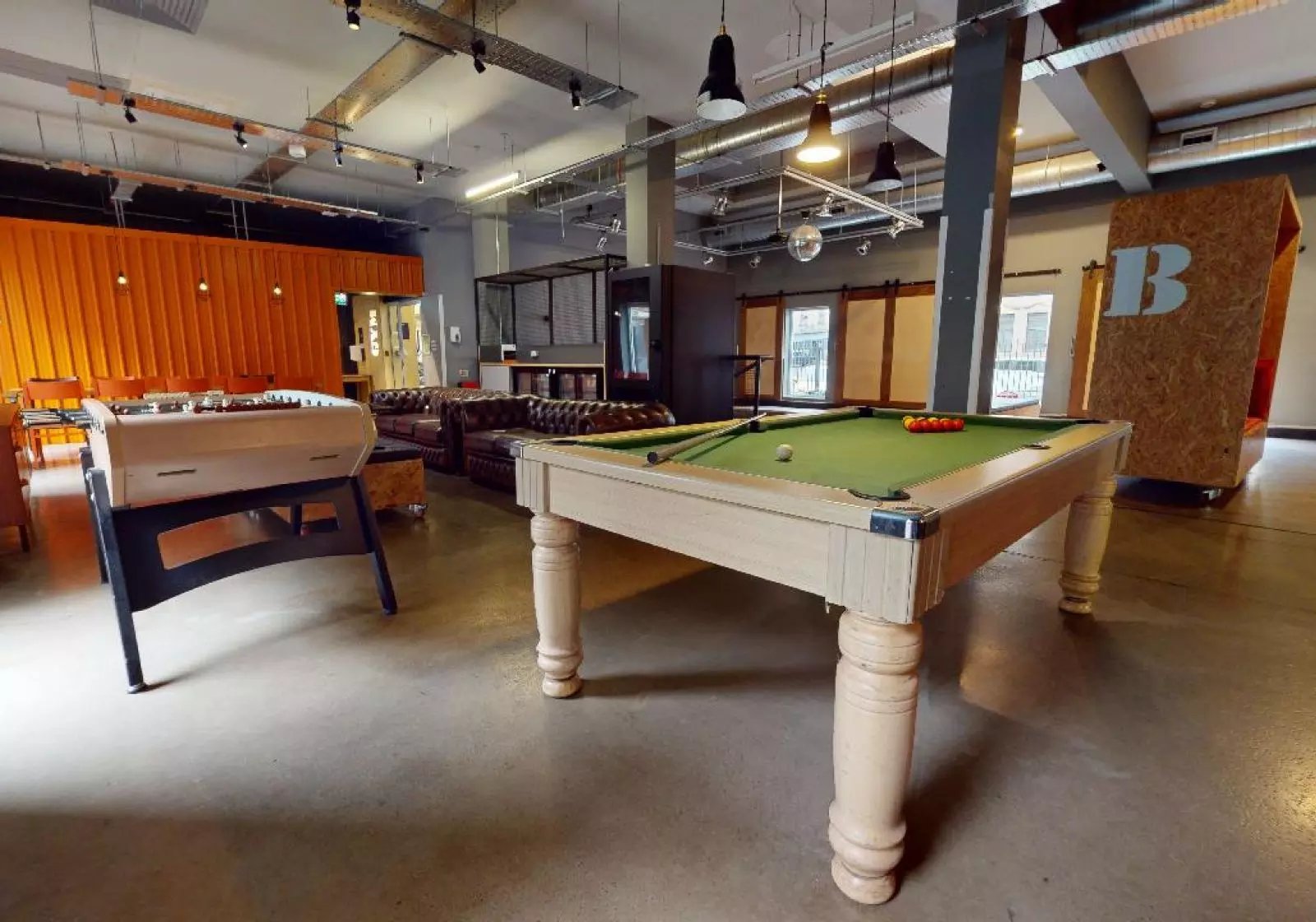 Foosball table pool table leather sofas communal area at iQ Arkwright House in Bradford Student Accommodation
