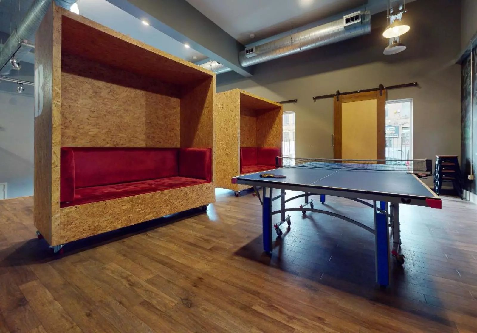Red velvet booths and ping pong table lounge area at iQ Arkwright House in Bradford Student Accommodation
