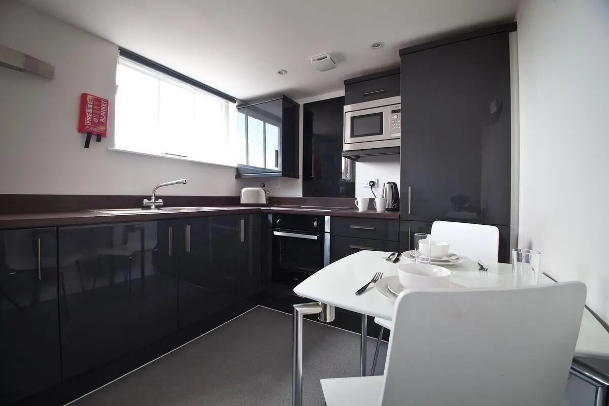 Modern dark cabinets microwave oven table kitchen at Dean Clarke Lofts in Exeter Student Accommodation