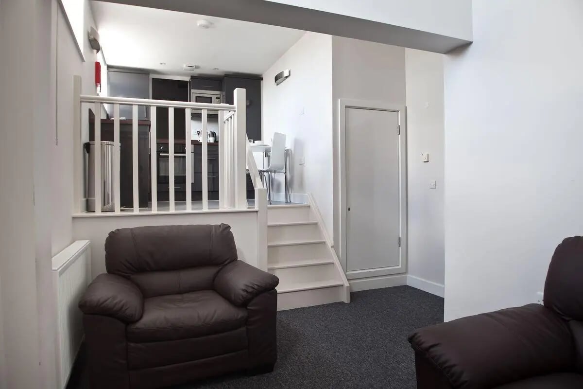 Brown leather sofa stairs kitchen living room at Dean Clarke Lofts in Exeter Student Accommodation