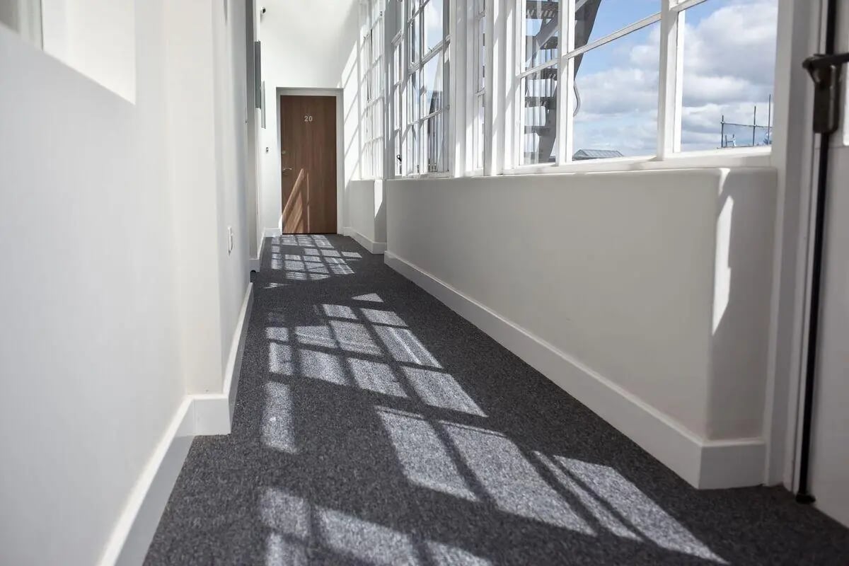 Hallway with gray carpet and wooden door hallway at Dean Clarke Lofts in Exeter Student Accommodation
