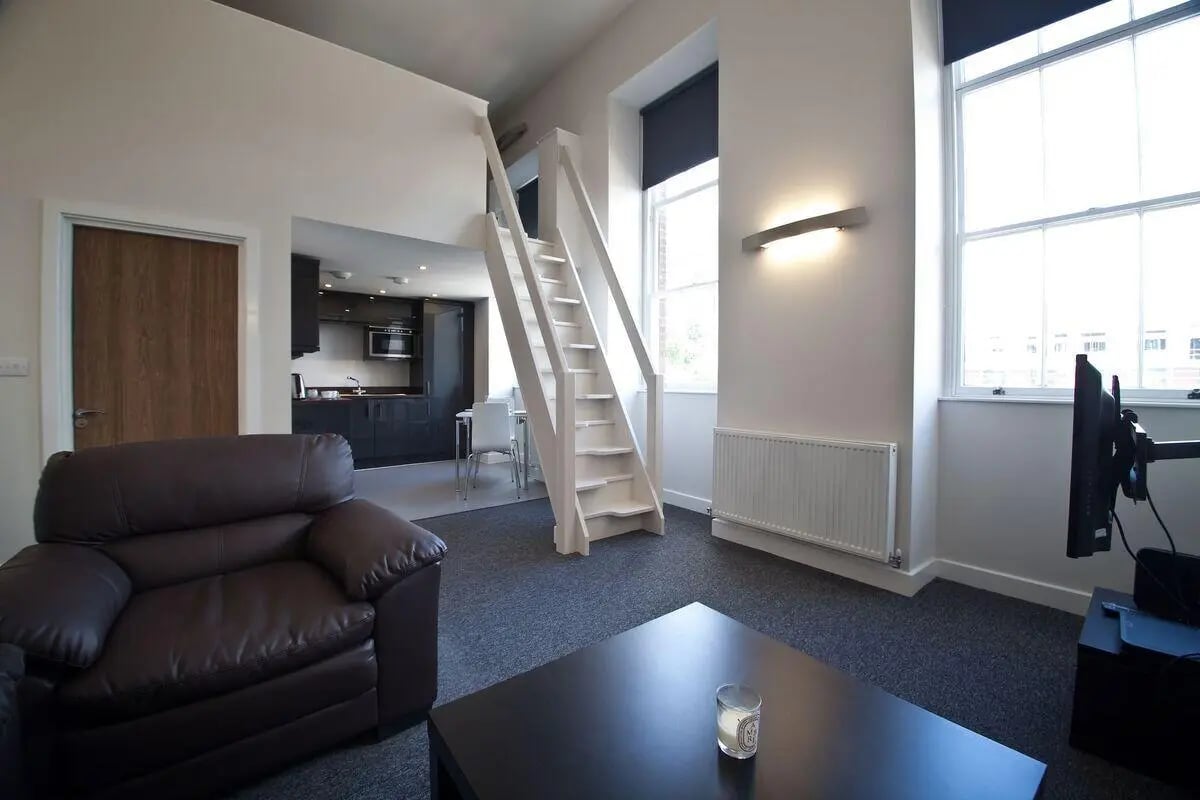 Sofa stairs kitchen and living room at Dean Clarke Lofts in Exeter Student Accommodation