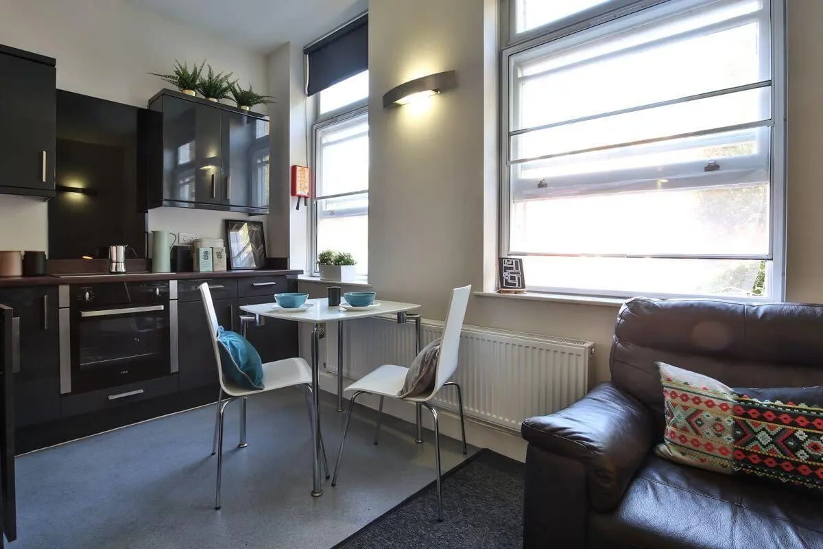 Kitchen and dining area with two chairs living room. at Dean Clarke Lofts in Exeter Student Accommodation