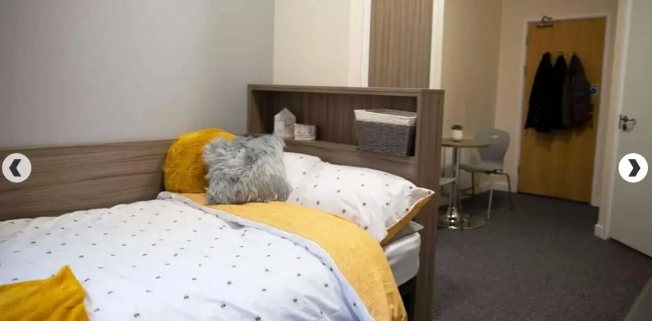 Bed with pillows and storage shelf bedroom at Lilian Knowles House in London Student Accommodation