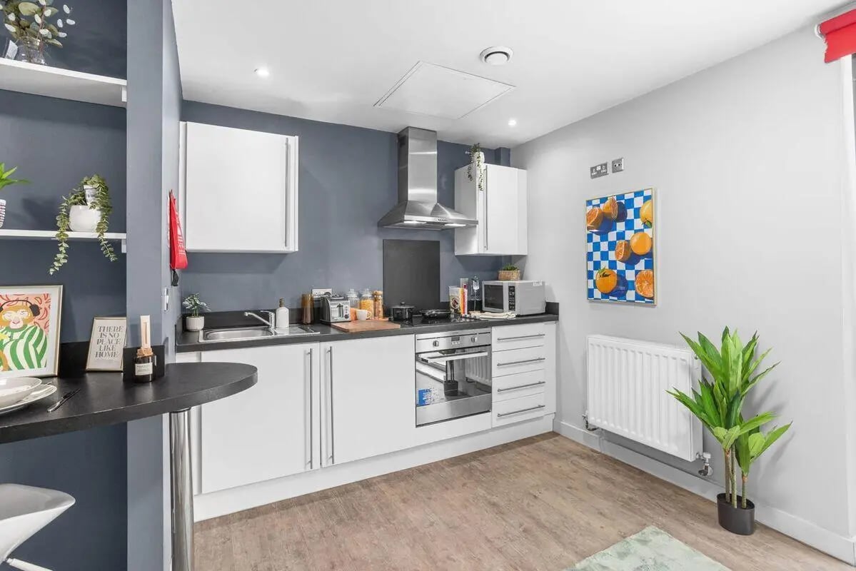 Modern kitchen with white cabinets appliances and bar area kitchen at Alwyn Court in Cardiff Student Accommodation