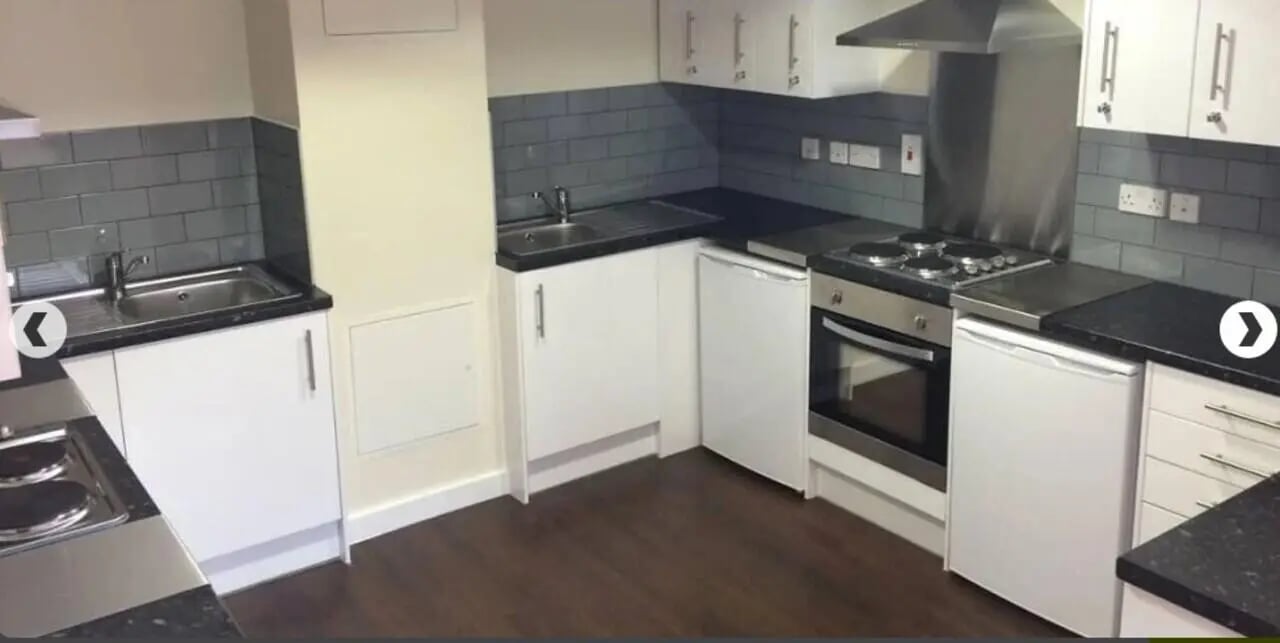 White cabinets sink stove fridge and dark tile kitchen at Alliance House in London Student Accommodation