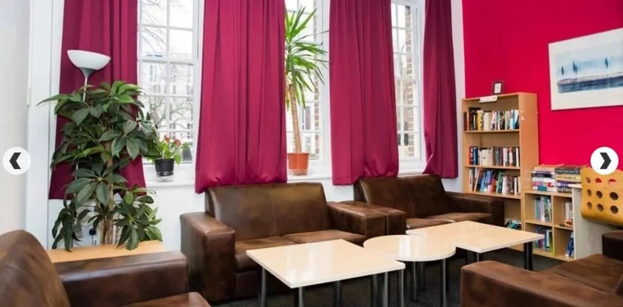 Brown sofas with tables and bookshelves living room at Alliance House in London Student Accommodation