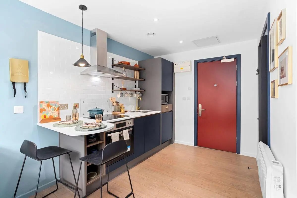 Kitchenette with breakfast bar and red door kitchen at Summit House in Cardiff Student Accommodation