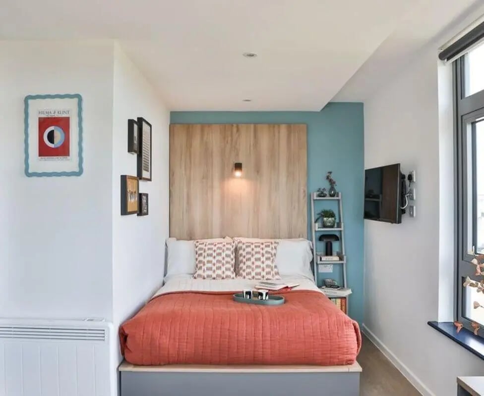 Bed with orange duvet framed art television bedroom at Summit House in Cardiff Student Accommodation