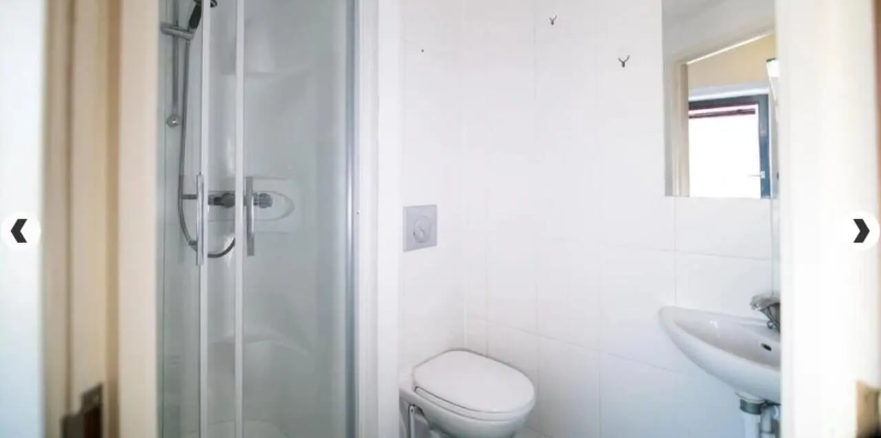 Shower toilet sink white tiled bathroom at The Craft Building in London Student Accommodation